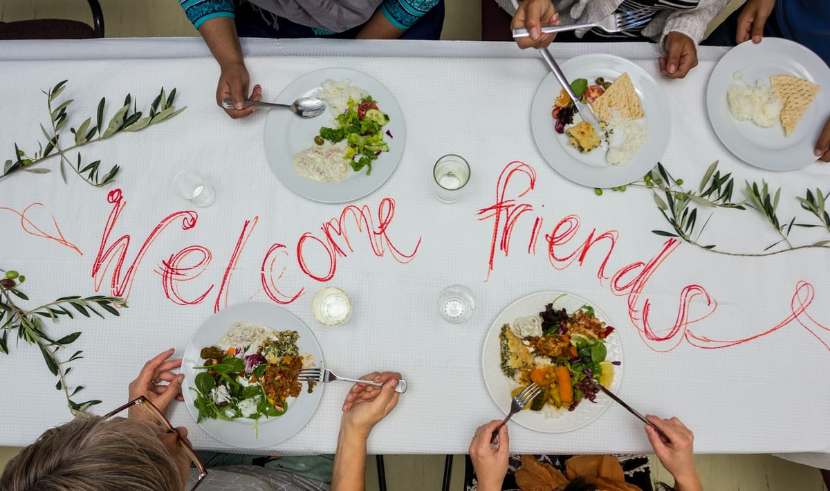 A long table set for a welcome meal, seen from above